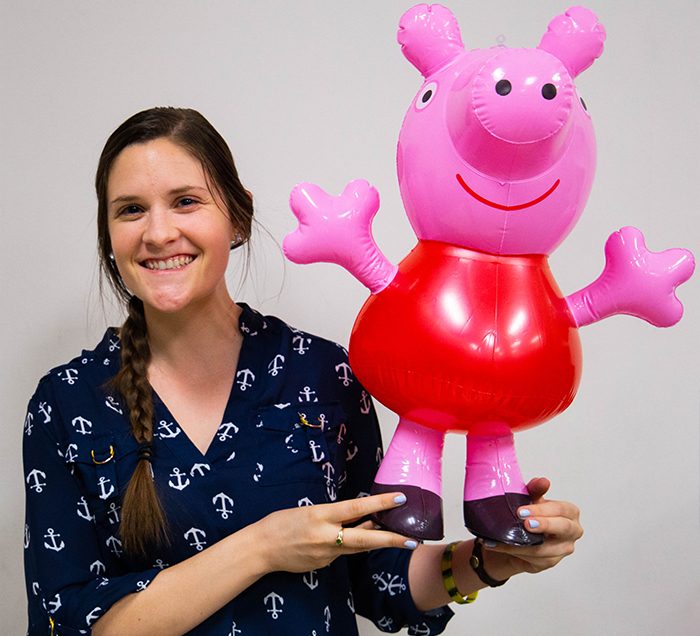 Girl holding blow up Peppa Pig