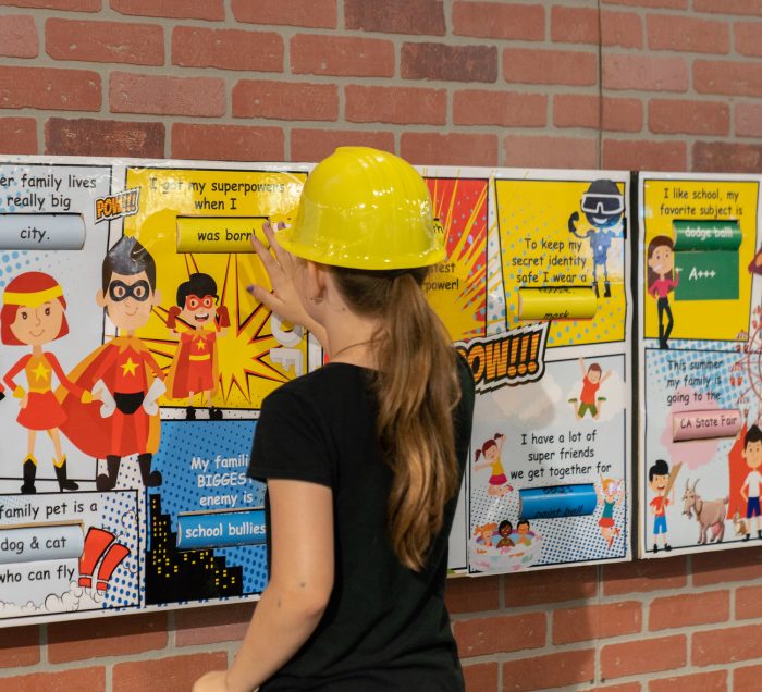 girl in hard hat with exhibit