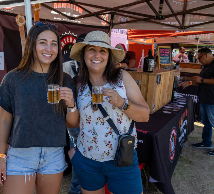 Two women holding glasses of beer at Brewfest