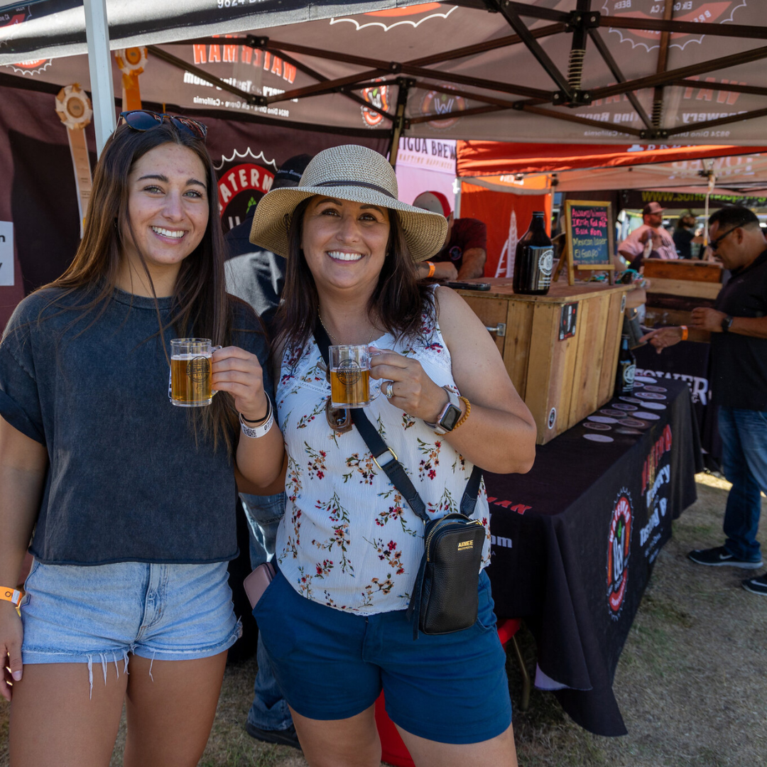 Two women holding glasses of beer at Brewfest