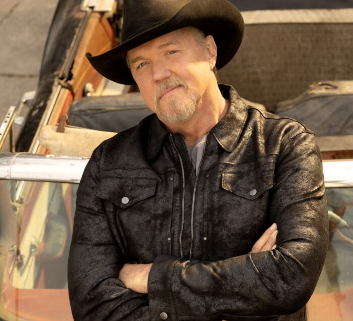 Trace Adkins leaning against a car with his arms crossed