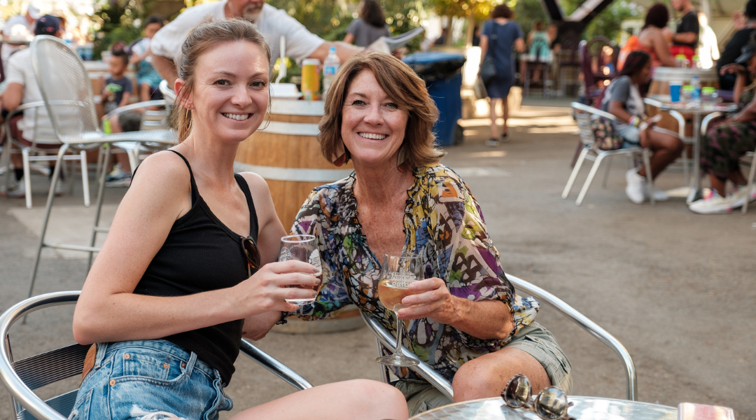 two women enjoying wine at the fair