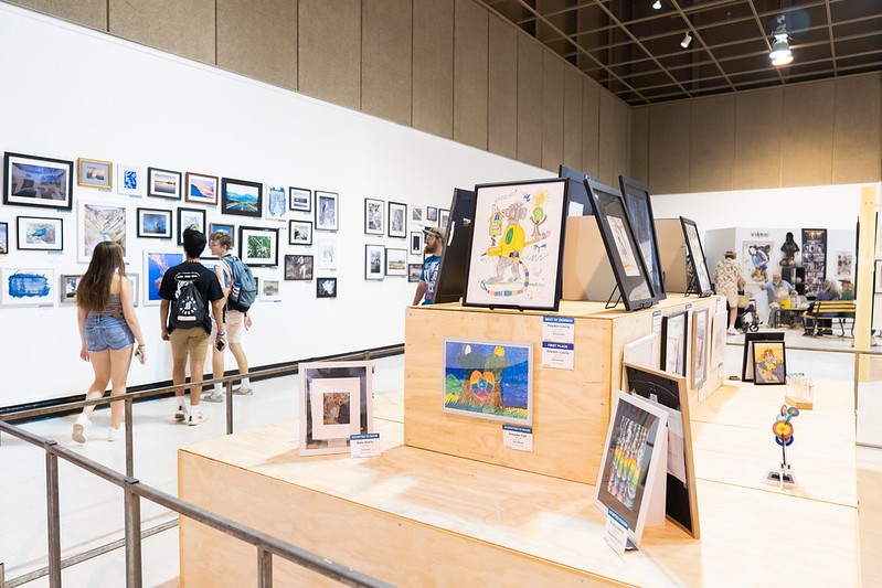 people looking at student art work on display